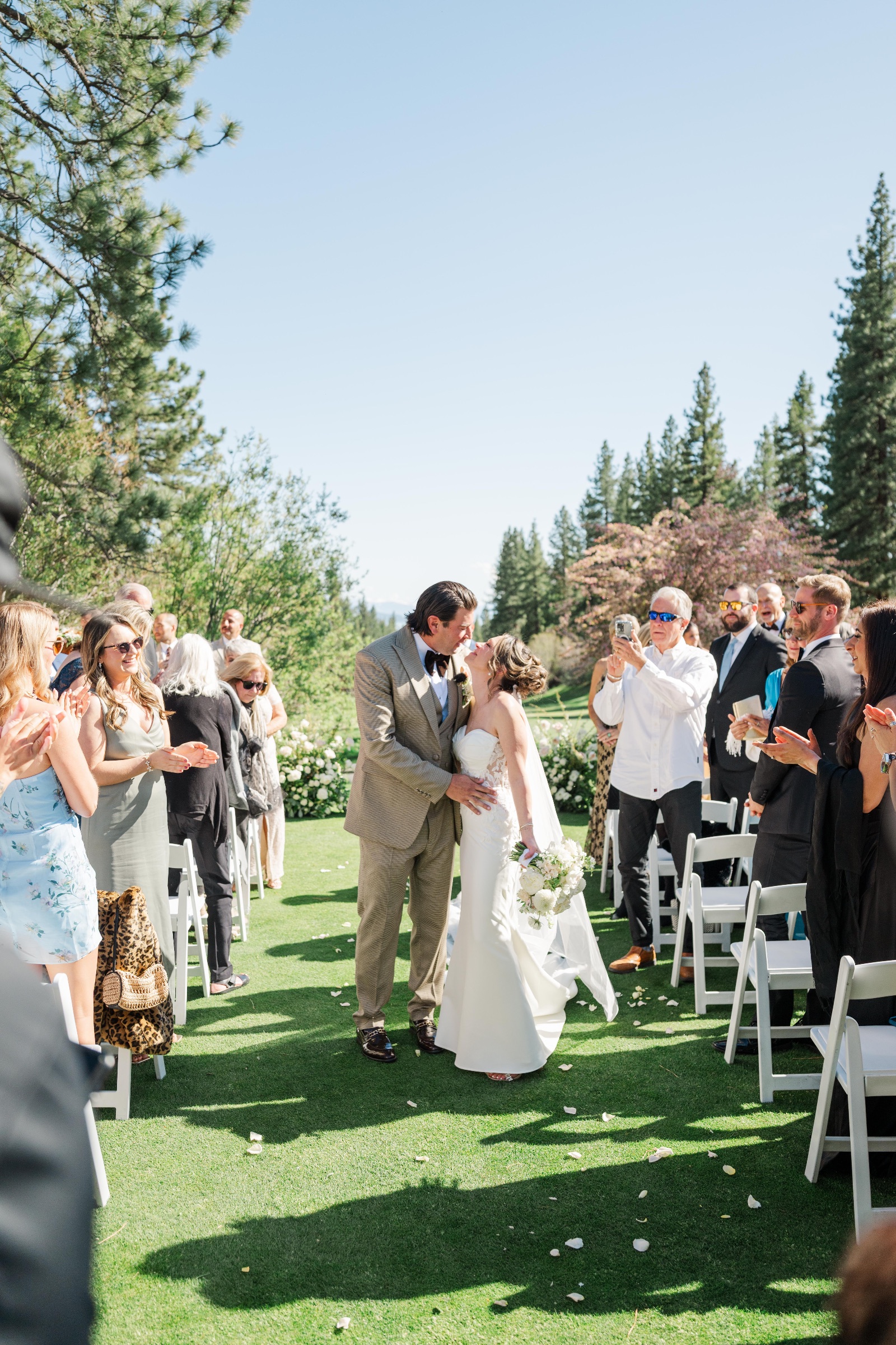 Brooke and Josh kiss as they walk back up the aisle past guests
