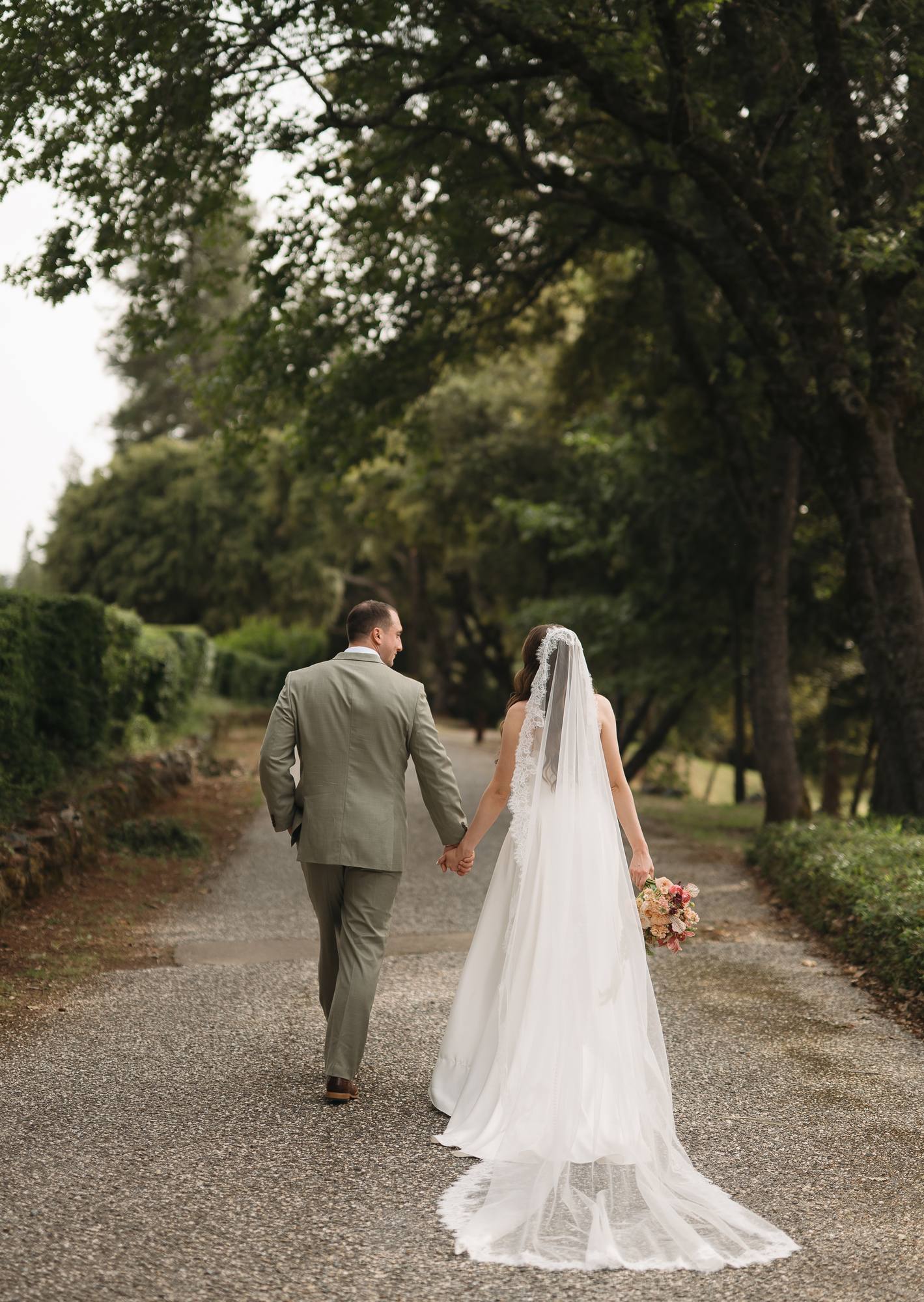 Couple walking a tree-lined lane, flowers grown on California land by Golden Flowers